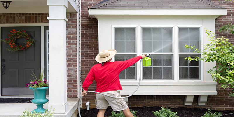 a man soft washing the house